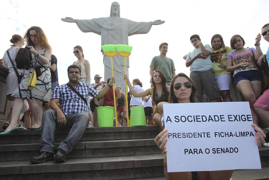 No Rio, ao pés do Cristo Redentor, eleitora empunha cartaz