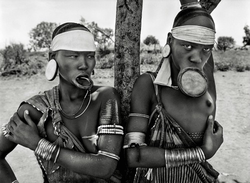  *Mulheres das aldeias de Mursi e Surma, no Parque Nacional de Mago, na Etiópia (2007). O uso de alargadores em formato de prato nos lábios é restrito às castas superiores 