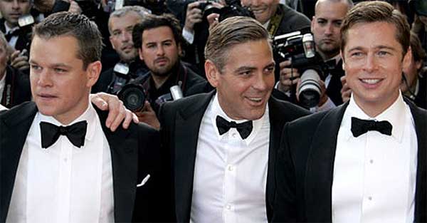Ladeado por duas celebridades: os atores Brad Pitt e Matt Damon