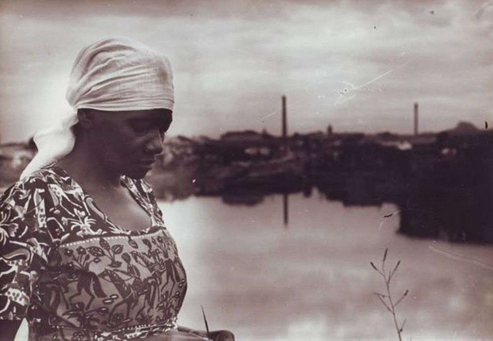 Carolina Maria de Jesus à margem do Rio Tietê e, ao fundo, a Comunidade do Canindé (Foto: Audálio Dantas, 1960)